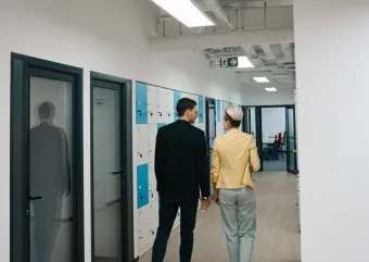 two people walking in a hallway