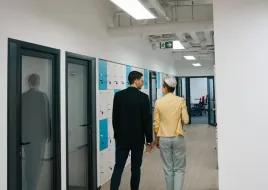 two people walking in a hallway